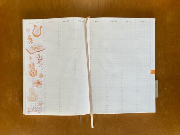 A Haroo Planner weekly view open to November 26 - December 1. A bunch of music-themed stickers decorate the left side of the page. A beige ribbon lays down the center as a bookmark.